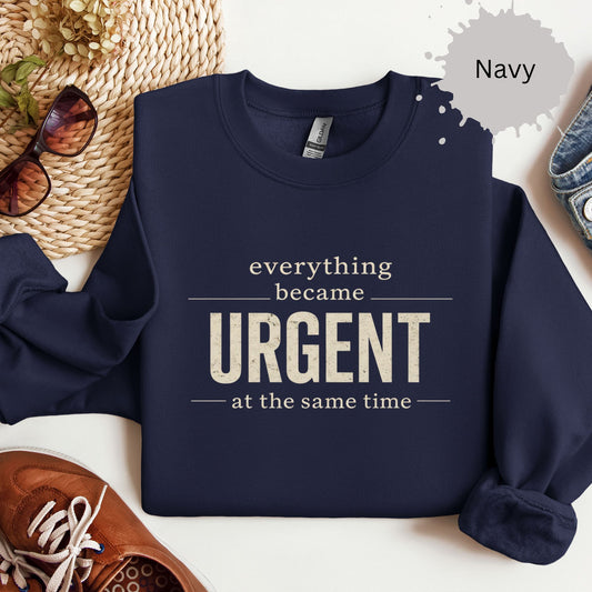 Crewneck sweatshirt with a bold text reading “Everything became urgent at the same time.”