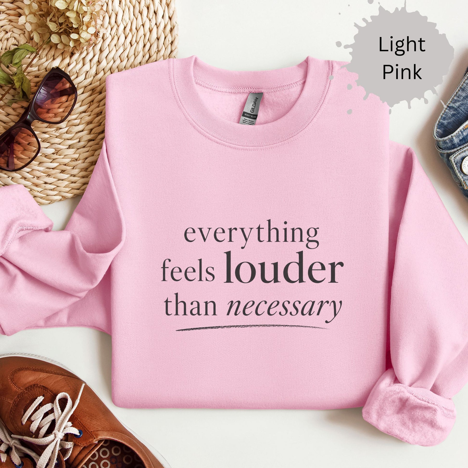 Crewneck sweatshirt with text reading “Everything feels louder than necessary."