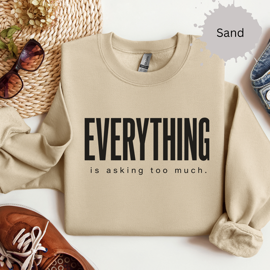 Crewneck sweatshirt with a bold text reading “Everything is asking too much.”