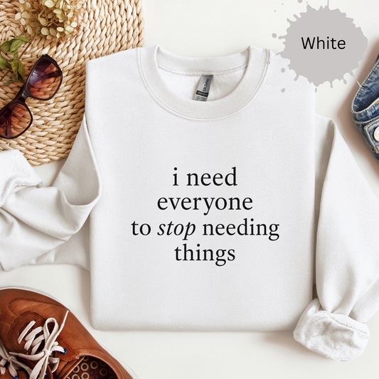 Crewneck sweatshirt with simple text text reading “I need everyone to stop needing things.”