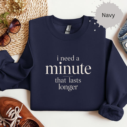 Crewneck sweatshirt with a bold text reading “I need a minute that lasts longer.”