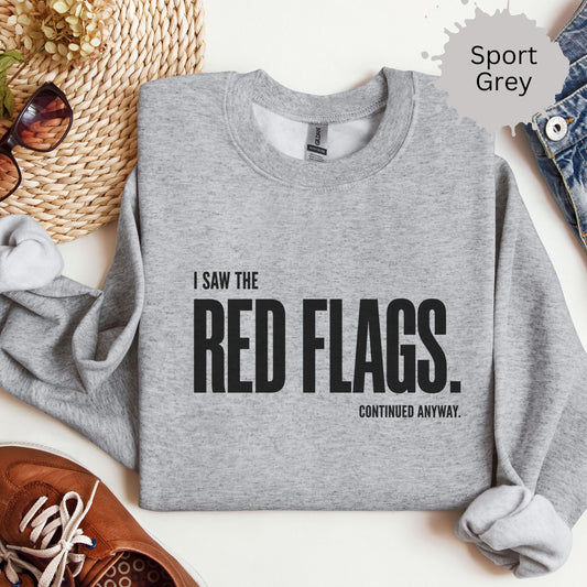 Womens sweatshirt with bold text reading “I saw the red flags. continued anyway.”
