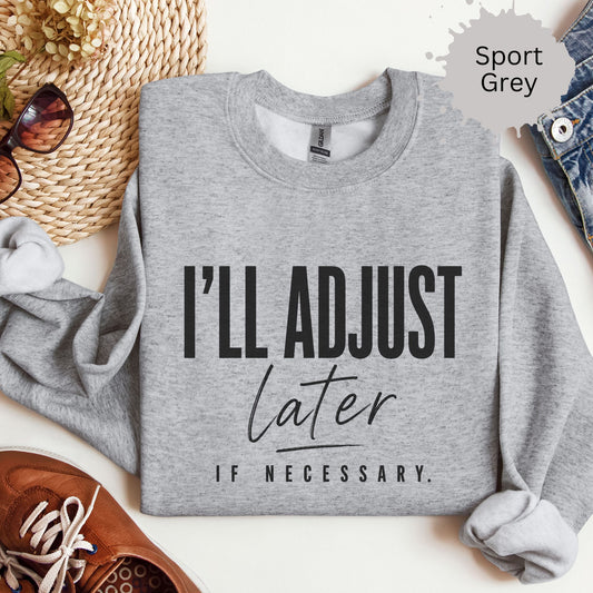 sweatshirt with typography reading “I’ll adjust later if necessary”