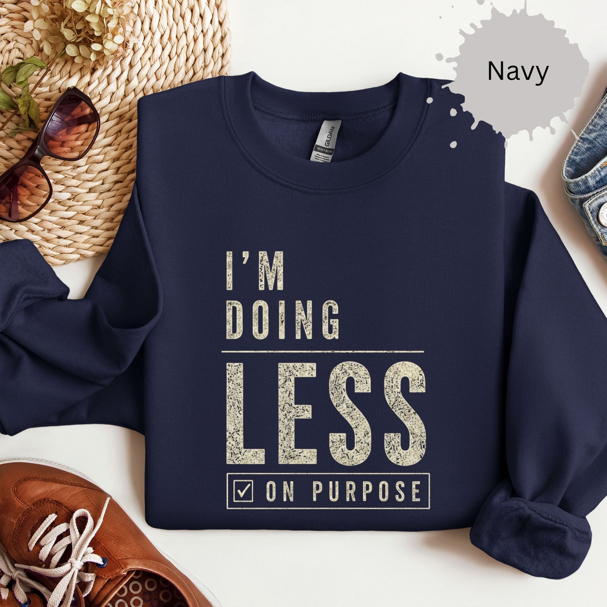 Crewneck sweatshirt with distressed bold text reading “I’m doing less on purpose.”
