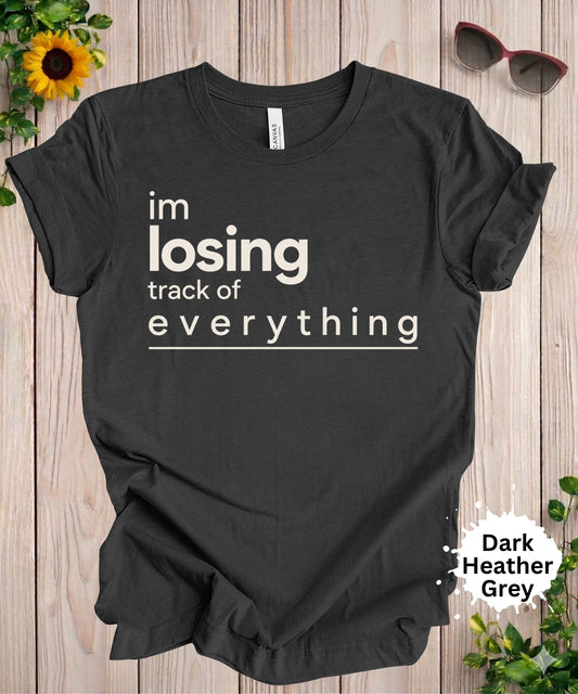 Women’s graphic T-shirt with the phrase “im losing track of everything” in bold minimalist typography