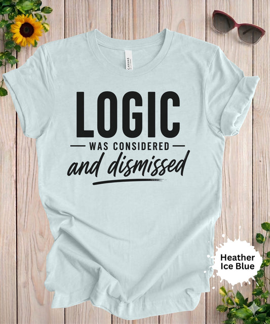Women’s graphic T-shirt featuring the phrase “Logic was considered and dismissed” in bold and script typography