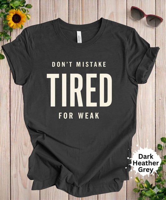Graphic tshirt with text that says “Don’t mistake tired for weak” in bold typography