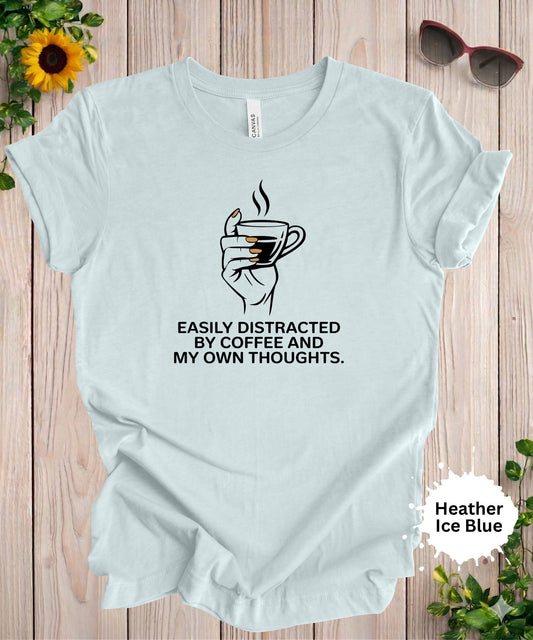 Woman wearing easily distracted by coffee and my own thoughts graphic t-shirt with minimalist coffee cup design