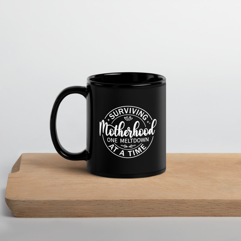 Surviving Motherhood One Meltdown at a Time Black Ceramic Coffee Mug